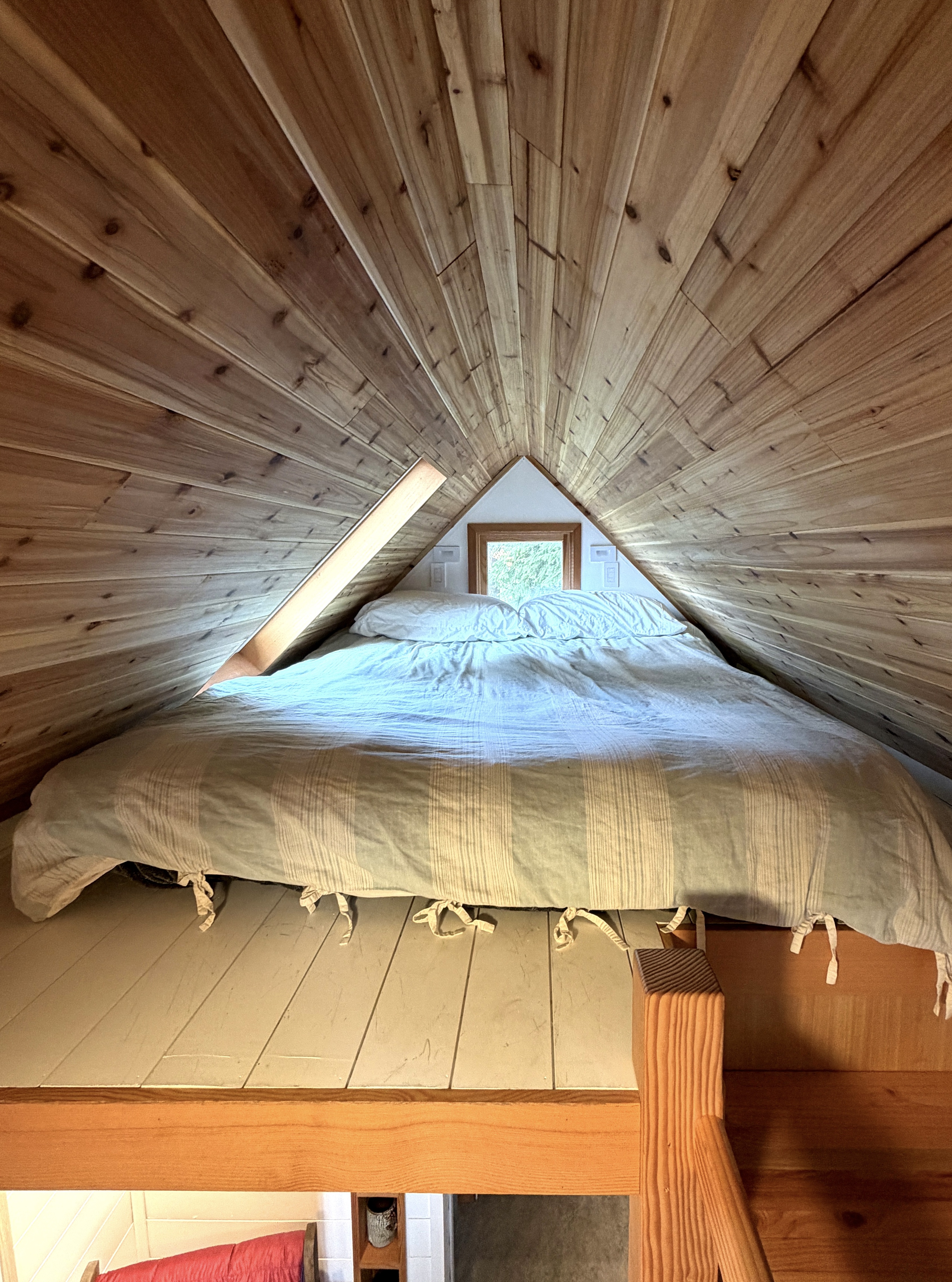 Cozy loft sleeping area under cedar plank ceiling