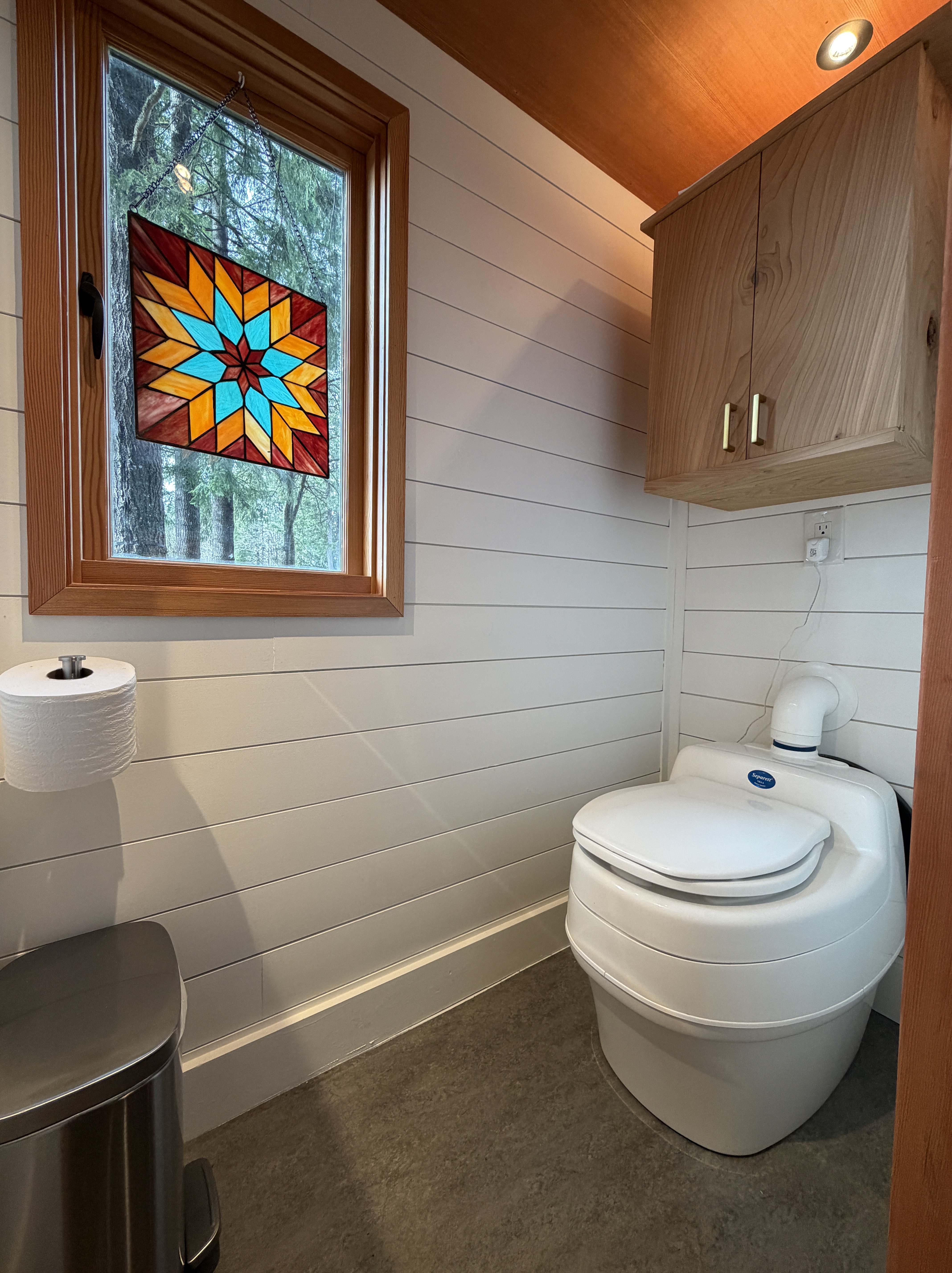 Private bathroom with stained glass window and composting toilet